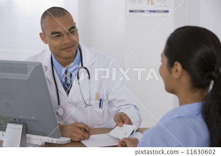 Male doctor handing prescription to patient Male doctor handing prescription to patient 11630602