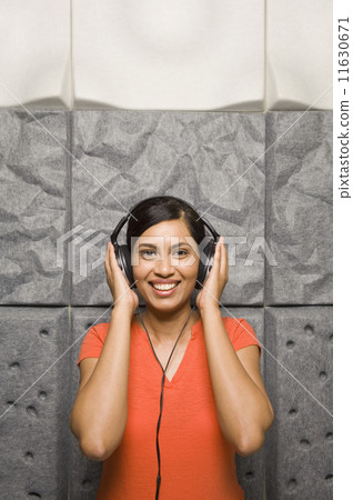 Indian woman listening to headphones Indian woman listening to headphones 11630671