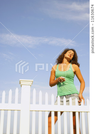 Young woman listening to mp3 player 11630674