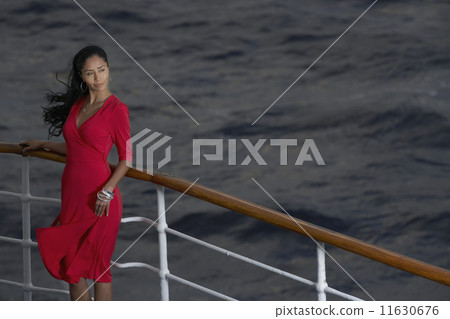 Hispanic woman leaning on ship railing 11630676