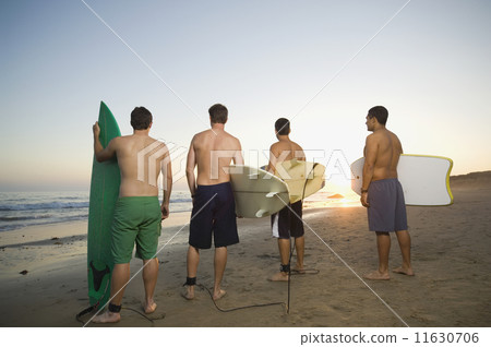 Rear view of multi-ethnic surfers Rear view of multi-ethnic surfers 11630706