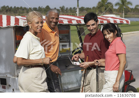 Multi-ethnic couples at food stand on golf course 11630708