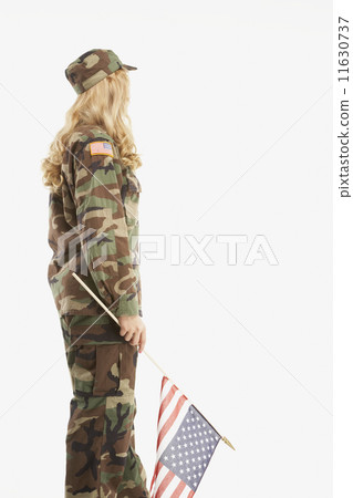 Woman wearing military uniform and holding American flag Woman wearing military uniform and holding American flag 11630737