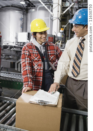 Man and woman talking in warehouse 11630750