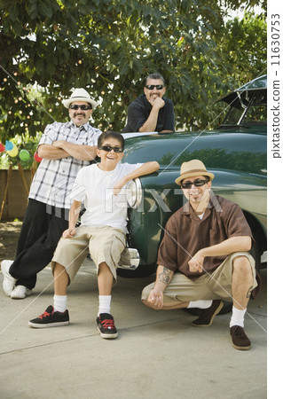 Multi-generational Hispanic male family members next to truck 11630753