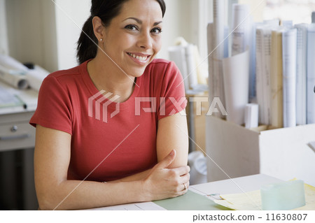 Hispanic female architect at desk 11630807