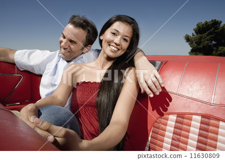 Multi-ethnic couple in backseat of convertible 11630809