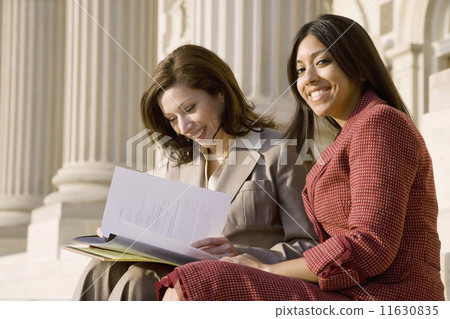 Multi-ethnic businesswomen looking at paperwork 11630835