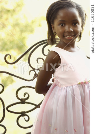 Young African girl smiling next to gate Young African girl smiling next to gate 11630851