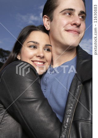 Multi-ethnic couple hugging outdoors Multi-ethnic couple hugging outdoors 11630883
