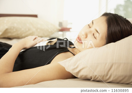 Asian woman sleeping with book 11630895