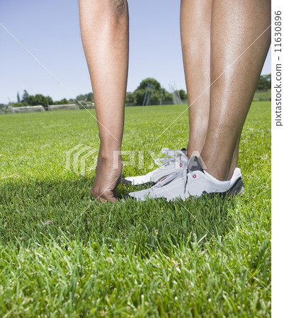 圖庫照片: african person touching toes in grass