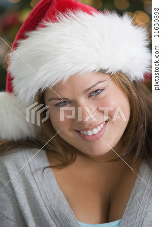 Hispanic woman wearing Santa Claus hat 11630898