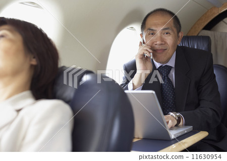 Asian businessman working on airplane 11630954