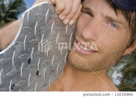 Hispanic man holding skateboard Hispanic man holding skateboard 11630960