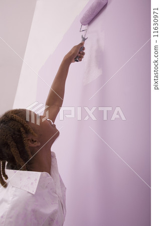 African American woman painting with roller African American woman painting with roller 11630971