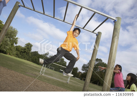 Asian boy hanging on jungle gym Asian boy hanging on jungle gym 11630995