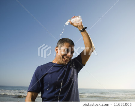Hispanic man pouring water over head 11631005
