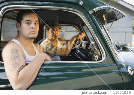 Hispanic men with tattoos sitting in truck Hispanic men with tattoos sitting in truck 11631059