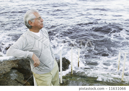 Man standing on stairs by the sea Man standing on stairs by the sea 11631066