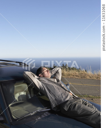 Male driver resting on his car hood 11631068