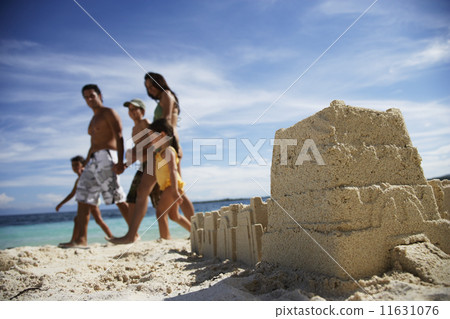 Hispanic family walking past sandcastle 11631076