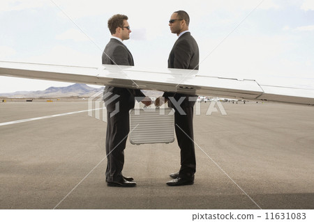 Multi-ethnic businessmen exchanging briefcase 11631083