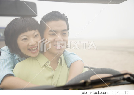 Asian couple hugging in convertible 11631103