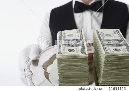 Close up of stacks of money on silver platter Close up of stacks of money on silver platter 11631133
