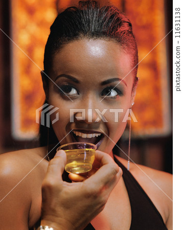 African woman drinking shot at nightclub 11631138