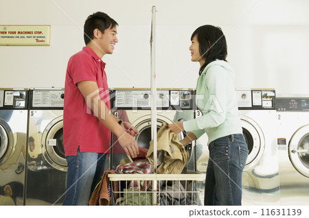 Asian couple in laundromat Asian couple in laundromat 11631139