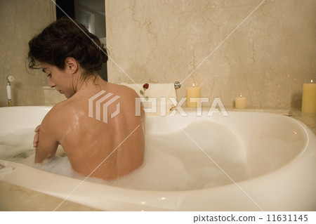 Woman sitting in bubble bath 11631145