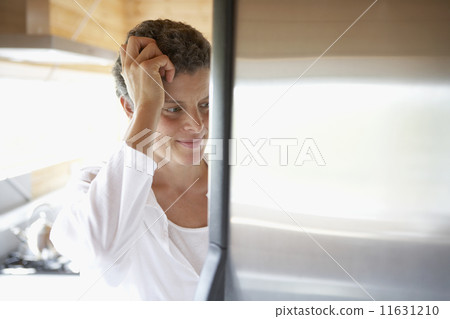 Mixed Race woman looking in refrigerator Mixed Race woman looking in refrigerator 11631210