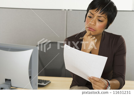 Businesswoman reading papers at desk 11631231