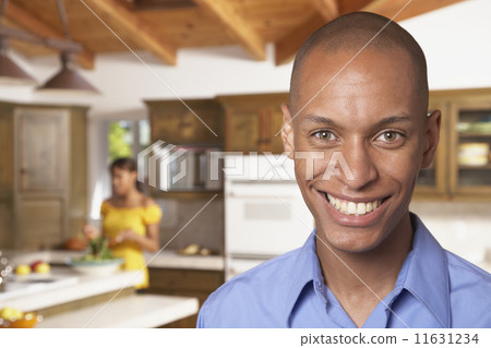 African man smiling with wife in background African man smiling with wife in background 11631234