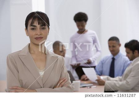 Indian businesswoman with co-workers in background 11631287