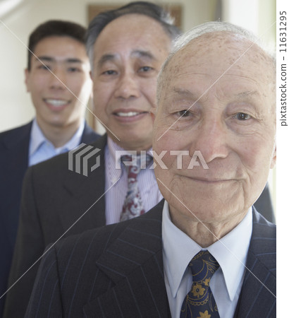 Senior Asian man with family members in background Senior Asian man with family members in background 11631295