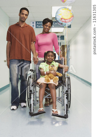 African girl smiling in wheelchair with parents in hospital African girl smiling in wheelchair with parents in hospital 11631305