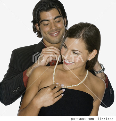Mixed Race man fastening girlfriend's necklace Mixed Race man fastening girlfriend's necklace 11631372