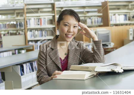 Asian woman with books in library 11631404