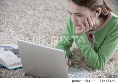 Young girl lying on the floor with laptop Young girl lying on the floor with laptop 11631429