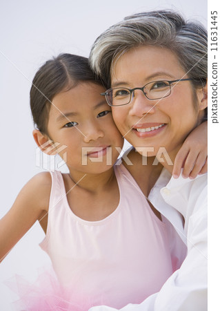 Asian mother and daughter in ballet outfit hugging Asian mother and daughter in ballet outfit hugging 11631445