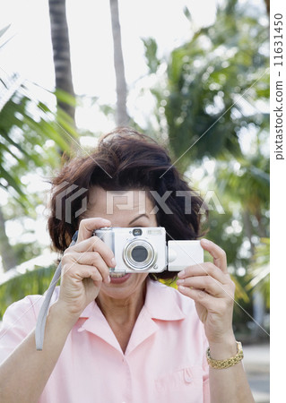 Hispanic woman taking photograph 11631450