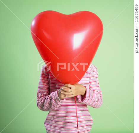 Hispanic girl holding balloon in front of face 11631499