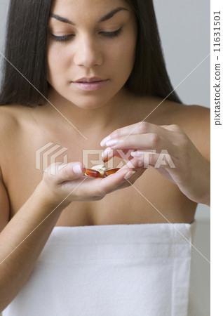 Young woman sorting out handful of pills  11631501
