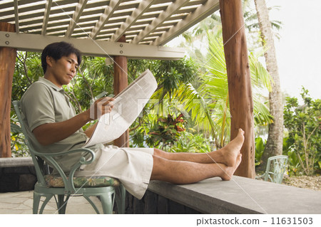 Asian man reading newspaper Asian man reading newspaper 11631503