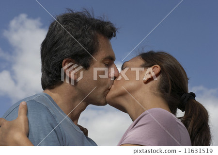 Low angle view of Hispanic couple kissing 11631519