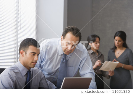 Hispanic businessmen looking at laptop 11631520