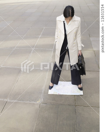 Hispanic businesswoman standing on map 11631554