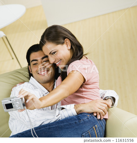 Multi-ethnic couple taking own photograph Multi-ethnic couple taking own photograph 11631556